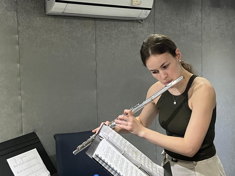 Dora is practicing her flute inside the exam room.