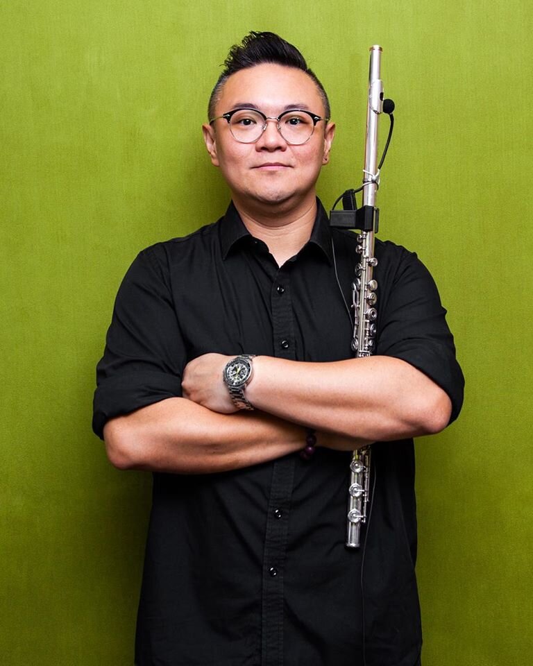 Stephen Lee is holding his flute, showing a handsome pose in this photo!
