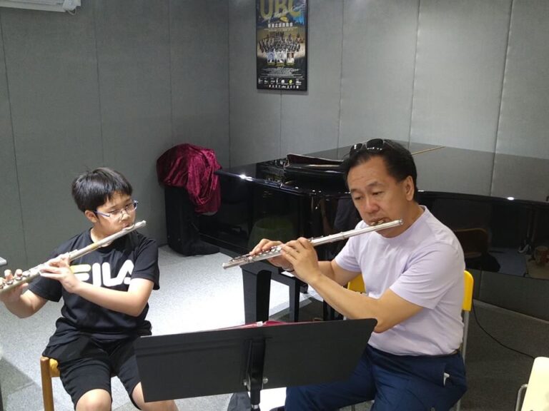 A young student and Joel are playing the flute together during a 1-on-1 music lesson in the exam room.
