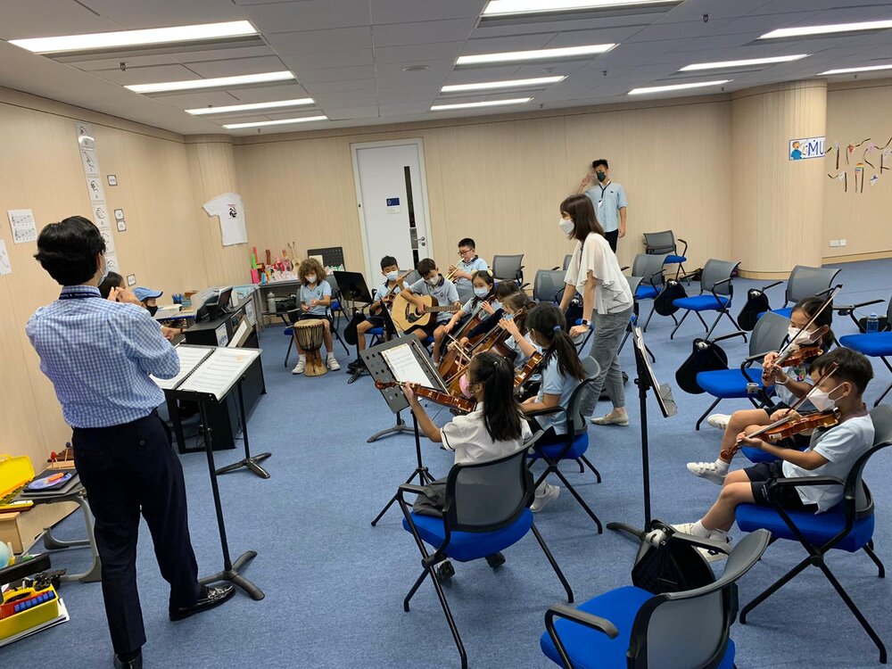 A group of students are having violin lessons together with Stephen.