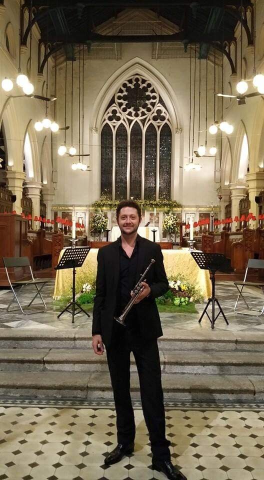 A selfie of Caspar Billington, holding up his trumpet as well.